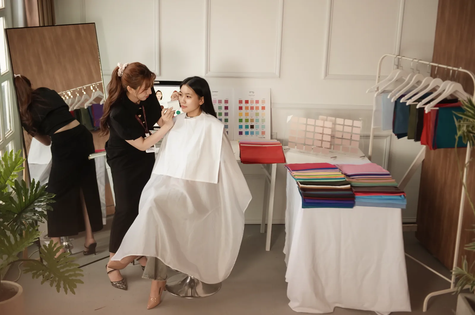 Giảng viên Gạo Nâu khoác drape trắng trung tính cho học viên trước khi soi sắc tố Personal Color